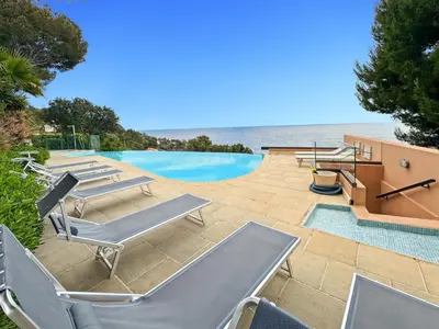 a pool with lounge chairs and the ocean in the background at Green Heaven Apt, Rickeys in Cap d'Ail