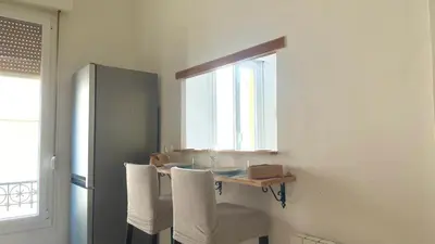 a kitchen with a table with chairs and a window at La Baieta - Typical Nice Apartment in Nice
