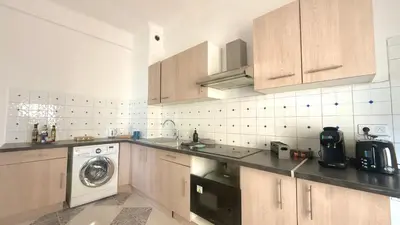 a kitchen with wooden cabinets and a washing machine at La Baieta - Typical Nice Apartment in Nice