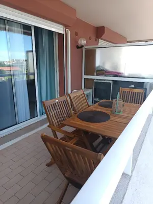 a wooden table and chairs on a balcony at Nice studio 5 minutes walk from the beach in Cagnes-sur-Mer