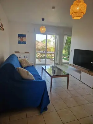 a living room with a blue couch and a television at Appartement 2 P calme in Cagnes-sur-Mer
