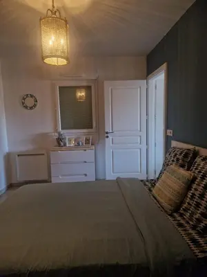 a bedroom with a bed and a window and a chandelier at Appartement 2 P calme in Cagnes-sur-Mer