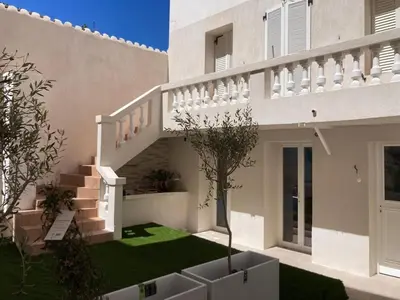 a white house with a staircase in a yard at Appartement Duplex Bord de Mer in Cagnes-sur-Mer