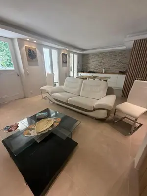 a living room with a white couch and a table at Appartement Duplex Bord de Mer in Cagnes-sur-Mer