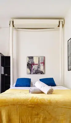 a bed with two blue pillows and the eiffel tower at Hyper Center - Superb Studio - Cozy - Wifi in Nice