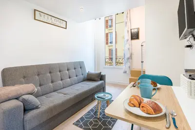 a living room with a couch and a table with bread at Blue Escape Nice in Nice
