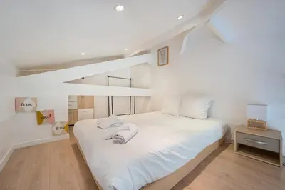 a white bedroom with a large white bed with white sheets at Blue Escape Nice in Nice
