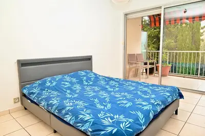 a bedroom with a bed with a blue blanket at Beautiful 3-room apartment with terrace in Nice
