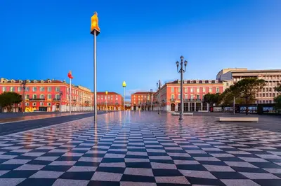 a city square with red buildings and a flag on a pole at Studio Masséna - Mer et Vieux Nice pour 4 personnes in Nice