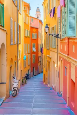 an alley with colorful buildings and a scooter on it at Studio Masséna - Mer et Vieux Nice pour 4 personnes in Nice
