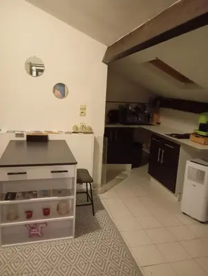 a kitchen with a table and a counter in a room at Appartement meublé 265 in Nice
