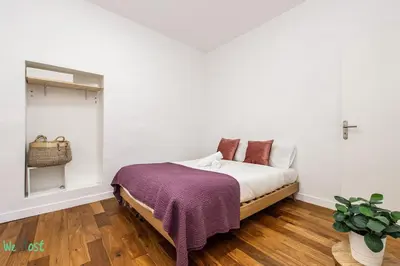 a bedroom with a bed with a cross on the wall at WeHost - MALONAT - Urban Cocoon # Old Town & Beaches in Nice
