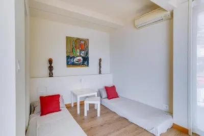 a white room with a bed and a table at Dina palace AP4462 By Riviera Holiday Homes in Villefranche-sur-Mer