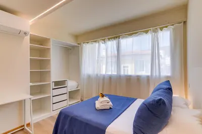 a small bedroom with a blue bed and a window at Dina palace AP4462 By Riviera Holiday Homes in Villefranche-sur-Mer