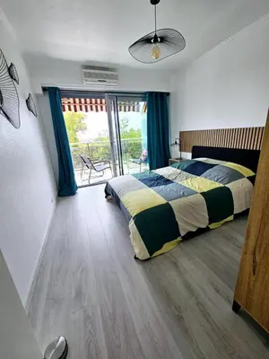 a bedroom with a bed and a large window at T2 Vue Mer avec Grande Terrasse & Parking 4 min Plage - SpiritofFamily06 in Cagnes-sur-Mer
