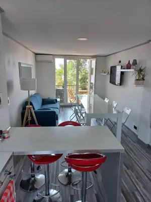a kitchen and living room with a counter and stools at Nice Signature Caucade in Nice