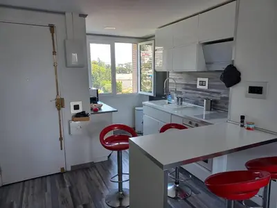 a kitchen with a counter and red chairs in it at Nice Signature Caucade in Nice