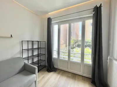 a living room with a couch and a large window at Nice Signature Andrioli in Nice