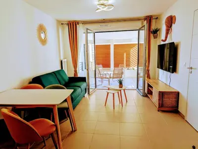 a living room with a green couch and a table at Appartement neuf T2 calme avec terrasse - Proche Marché Liberation in Nice
