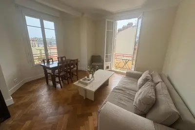 a living room with a couch and a table at Top Floor Central Steps from the sea in Nice