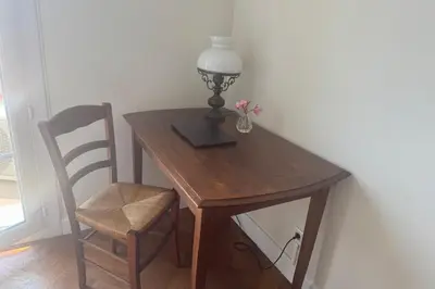 a wooden desk with a lamp and a chair at Top Floor Central Steps from the sea in Nice
