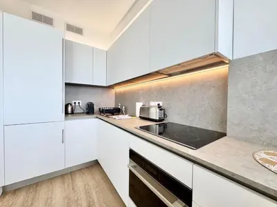 a kitchen with white cabinets and a counter top at Le Milord - Easy Home Booking in Nice