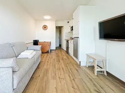 a living room with a couch and a flat screen tv at Élégance Azuréenne - piscine et parking in Villefranche-sur-Mer