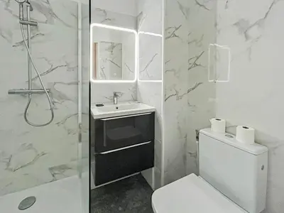 a white bathroom with a sink and a toilet at Élégance Azuréenne - piscine et parking in Villefranche-sur-Mer