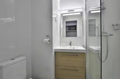 a white bathroom with a sink and a shower at Superbe 2 pièce tout confort - AC, piscine, Park in Villefranche-sur-Mer