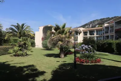 a courtyard with palm trees and a building at Superbe 2 pièce tout confort - AC, piscine, Park in Villefranche-sur-Mer