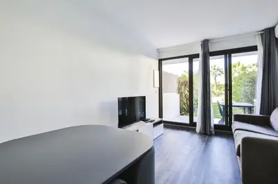 a living room with a couch and a television at Superbe 2 pièce tout confort - AC, piscine, Park in Villefranche-sur-Mer