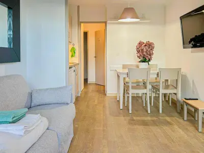 a living room with a couch and a table and chairs at Ange Gardien - AC, Parking, Piscine in Villefranche-sur-Mer