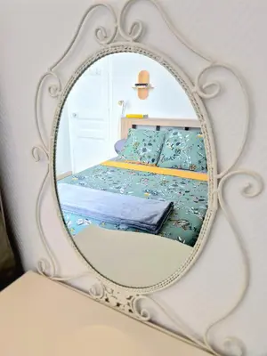 a mirror reflecting a bed in a bedroom at L'Appart by la Maïoun Guesthouse in Nice