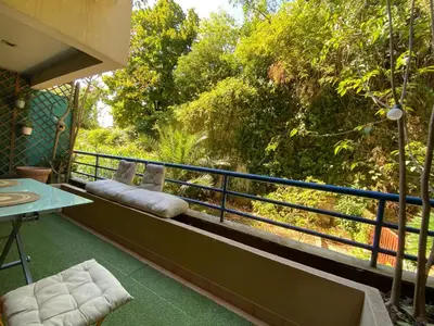 a balcony with a table and chairs and trees at Studio with Terrace near Beach in Nice