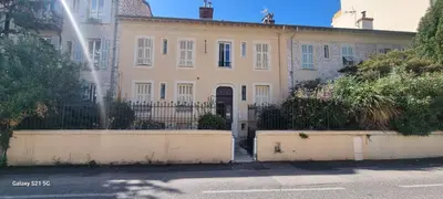 a large white house with a fence in front of it at Studio 1 pièce in Nice