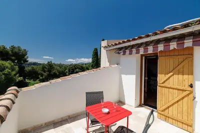 a red table and chair on the patio of a house at VILLA MONTE CRISTO - Villa conviviale a Nice - Superbe vue, piscine et jeux en plein air in Nice