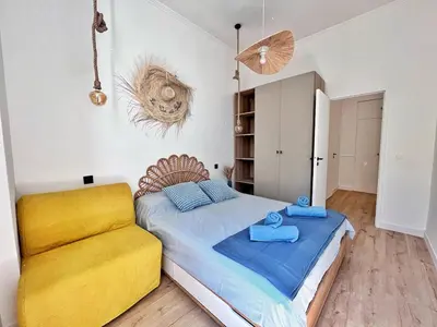 a bedroom with a bed and a yellow couch at Ref 118 Oliviera 2 Beds Apartment in Riquier in Nice