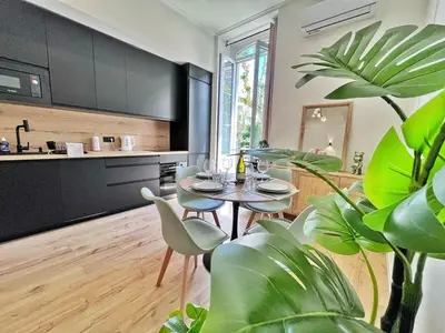 a living room with a table and chairs and a kitchen at Ref 118 Oliviera 2 Beds Apartment in Riquier in Nice