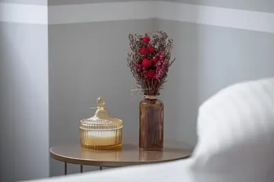 a vase with red flowers on a table with a candle at 5 BEAUMONT - Magnifique 3P au style boheme - Quartier Garibaldi in Nice