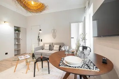 a living room with a table and a couch at 5 BEAUMONT - Magnifique 3P au style boheme - Quartier Garibaldi in Nice