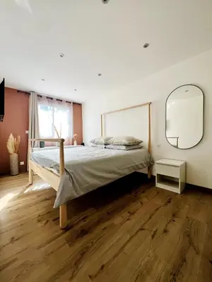 a bedroom with a bed and a large mirror at Lea's cozy nest with a sea-mountain view in Saint-Laurent-du-Var