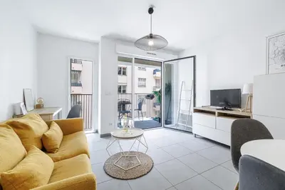 a living room with a couch and a table at Charmant 2 pièces lumineux Quartier du Port in Nice