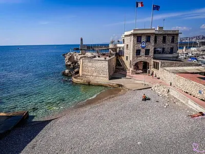a building on a beach next to the water at Joli studio, quartier du port in Nice