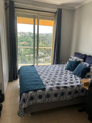 a bedroom with a bed and a large window at Elegant apartment a Nice, Sea View in Nice