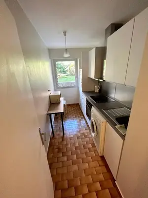 a small kitchen with a table and a window at Apparemment 2P centre Nice in Nice