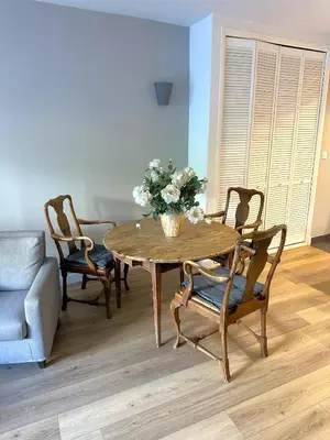a dining room table with chairs and a vase of flowers at Cocon Provençale à 5 min de la mer in Nice