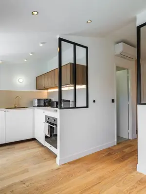 an open kitchen with white cabinets and wood floors at Magnifique studio boulevard gambetta - A in Nice