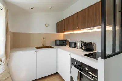 a kitchen with white cabinets and black appliances at Magnifique studio boulevard gambetta - A in Nice