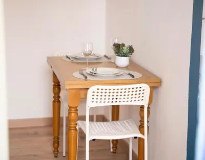 a wooden table with two white chairs and a table with wine glasses at Rêve Bleu de Nice - Terrace - Beach & Tram 5 min in Nice