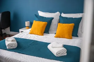 a bed with towels and pillows on it at Rêve Bleu de Nice - Terrace - Beach & Tram 5 min in Nice